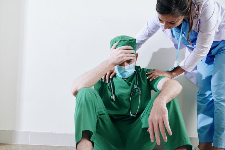 Nurse reassuring stressed surgeon